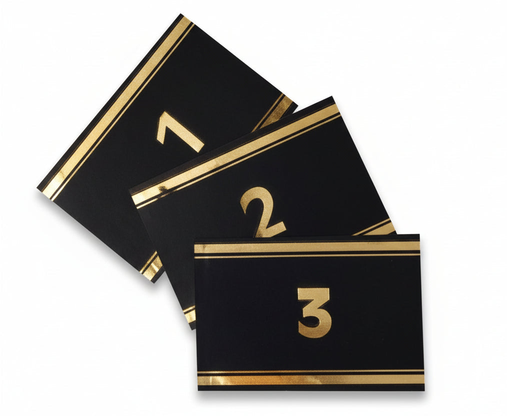 Three black labels with gold numbers 1, 2 and 3 written in gold for album spine labeling/organizing on a white background