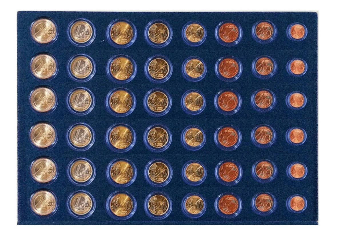A collection of 6 coin sets displayed in a blue velvet coin tray, photographed from above against a plain white background.