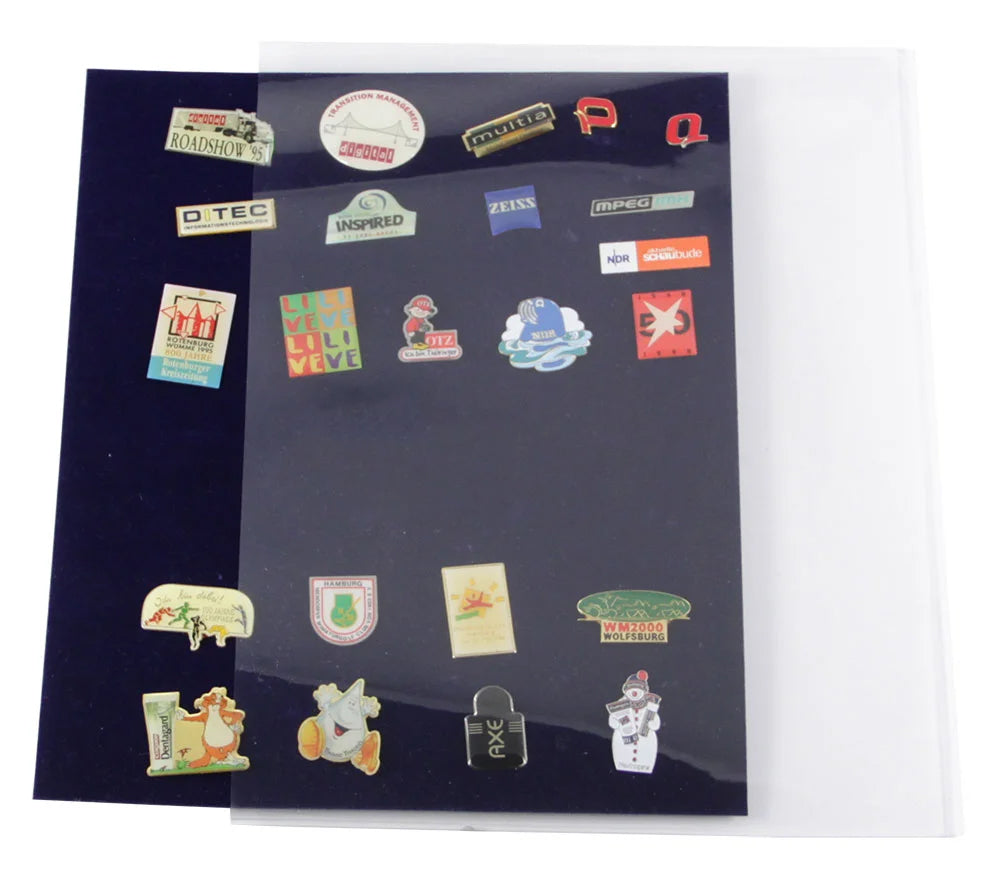 Collection of various small pins on a blue velvet page, half way inside a clear protector