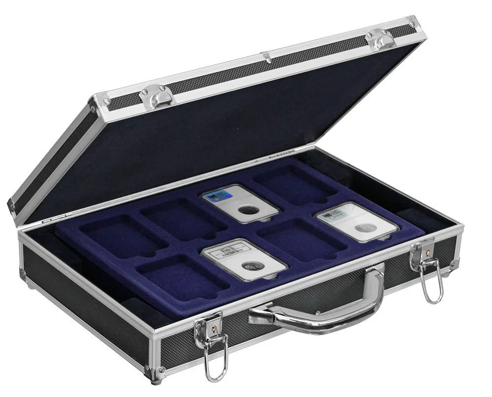 Graded coin slab collection in a black aluminum coin carrying case with blue velvet coin trays on a white background