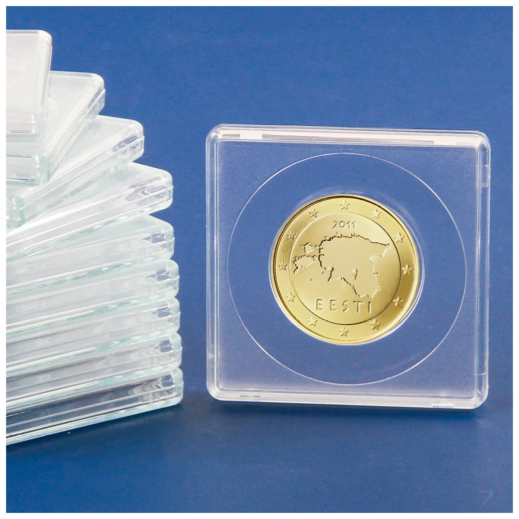 Gold coin in a clear protective case next to a stack of similar cases on a blue background
