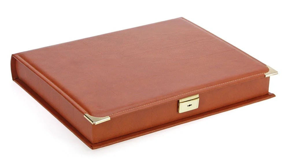 Closed saddle tan binder that acts as a built in slipcase, with gold accents and lock on a white background