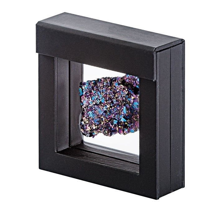 Black square frame with transparent window made of film that is molded to a multicolored mineral on a white background