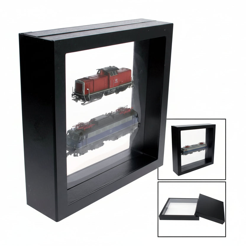 Black square frame/shadowbox with transparent window made of film that is molded to two model trains with an inset image of how to insert the collectible on a white background