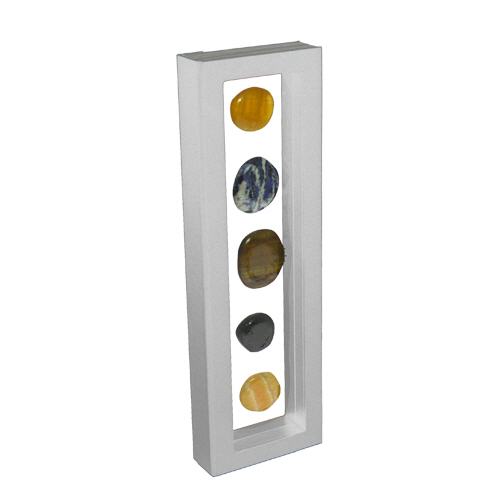 White rectangular frame/shadowbox with transparent window made of film that is molded to a collection of stones on a white background