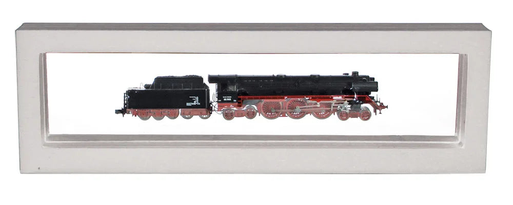 White rectangular frame/shadowbox with transparent window made of film that is molded to a model train on a white background