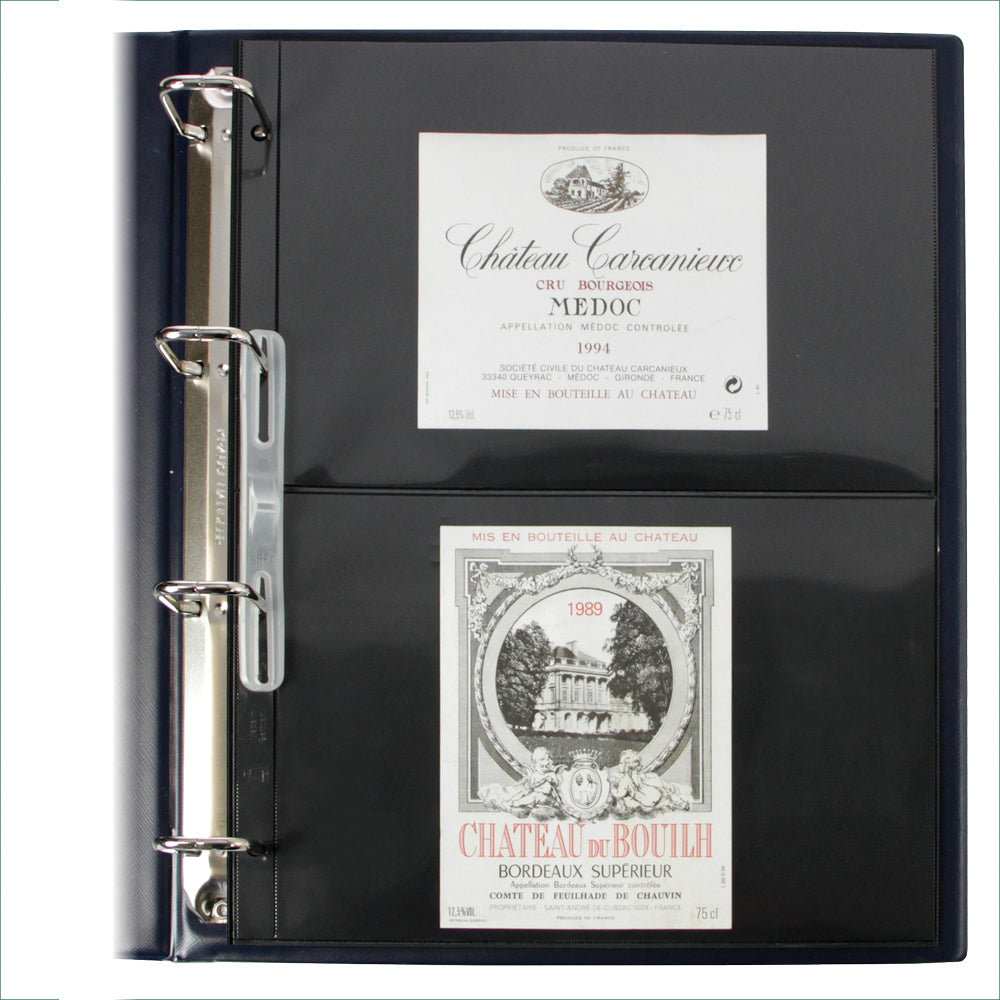 Open blue collection album displaying a page with wine labels from Chateau Carcanie and Chateau de Bouli on a white background
