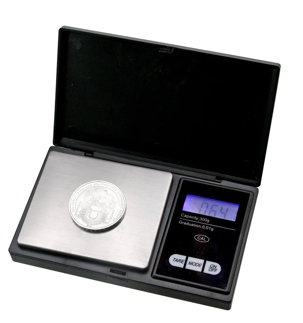 Black digital pocket scale with a coin on a white background