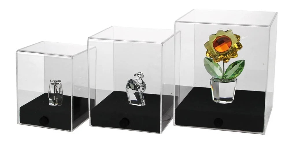 3 acrylic display cases with a black bases holding crystal collectibles on a white background