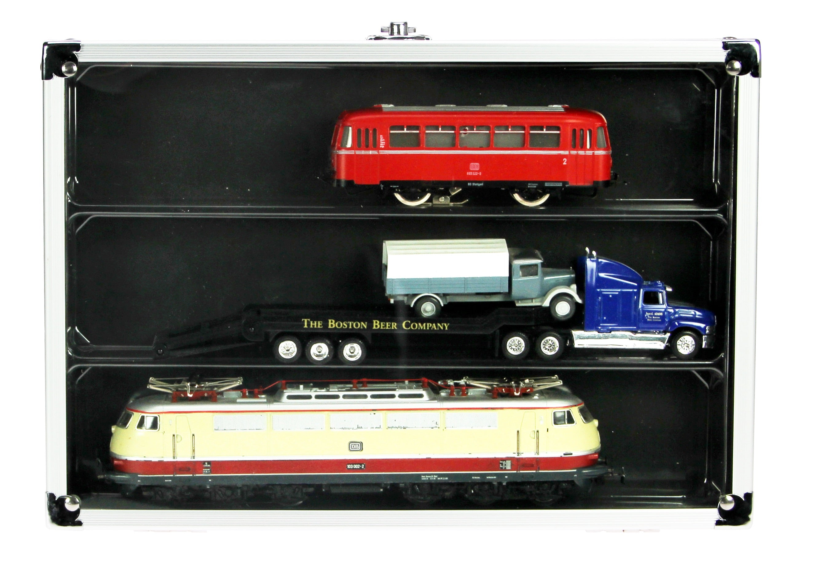 Aluminum display case with 3 compartments filled with model trains & trucks, closed with an acrylic lid on a white background