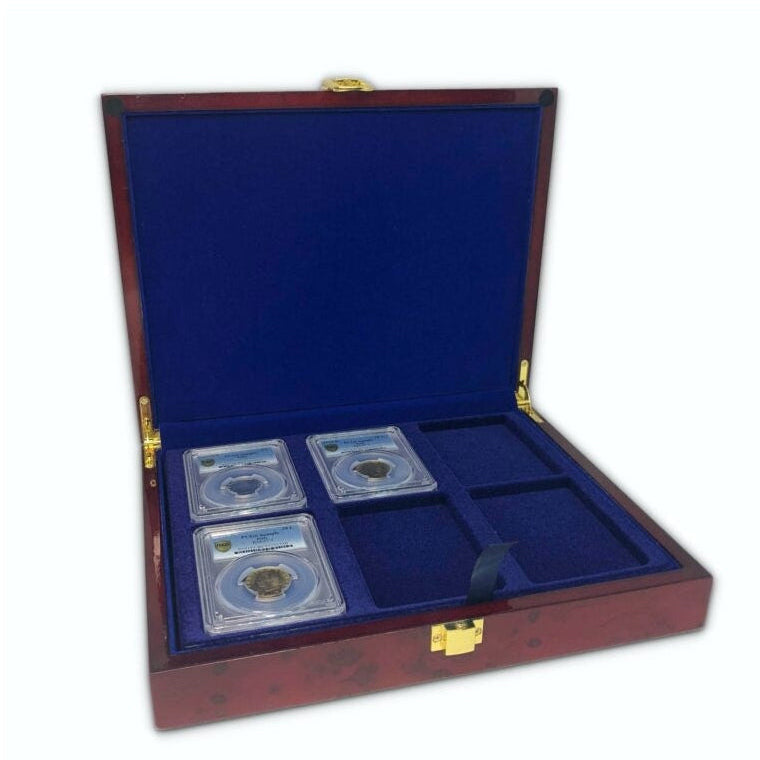 Open burlwood coin collection box with blue velvet trays holding a coin slab collection on a white background