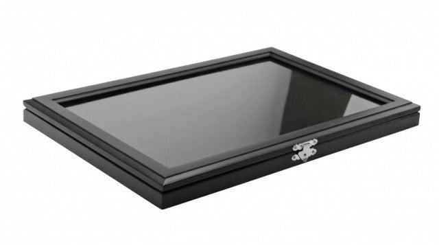 Black wood display case with a glass top closed, inside containing a black velvet insert on a white background.