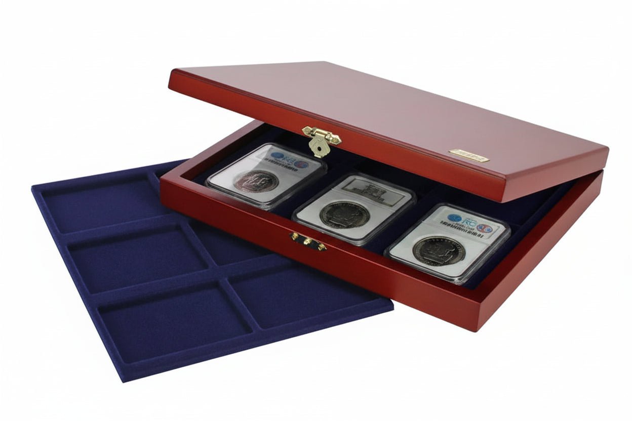 Open wooden coin collection box with blue velvet trays holding a coin slab collection accompanied by an additional blue tray on a white background
