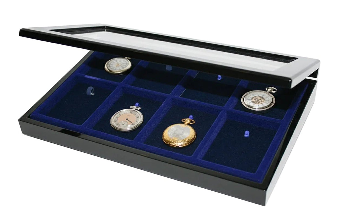 Antique pocket watches on a blue velvet tray inside of a black wooden high gloss display case with the acrylic glass lid open ajar on a white background