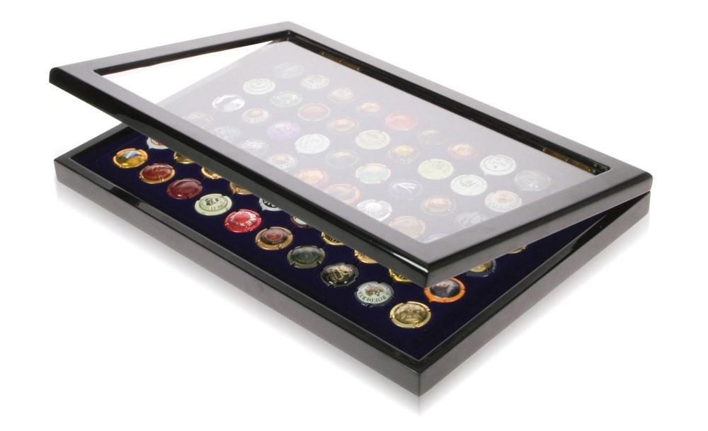 High gloss black display case with a clear lid open ajar, inside containing various champagne tops on a blue velvet insert on a white background.