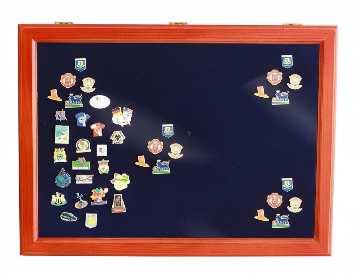 Overhead image of a wooden display case with a closed glass lid displaying various collectible pins on a blue velvet insert on a white background.