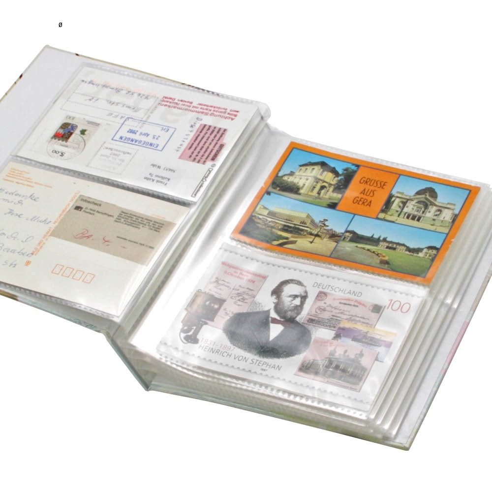 Collection of vintage postcards in an open postcard album on a white background