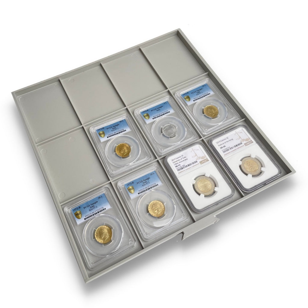 Gray grid coin tray drawer with a collection of graded coin slabs on a white background