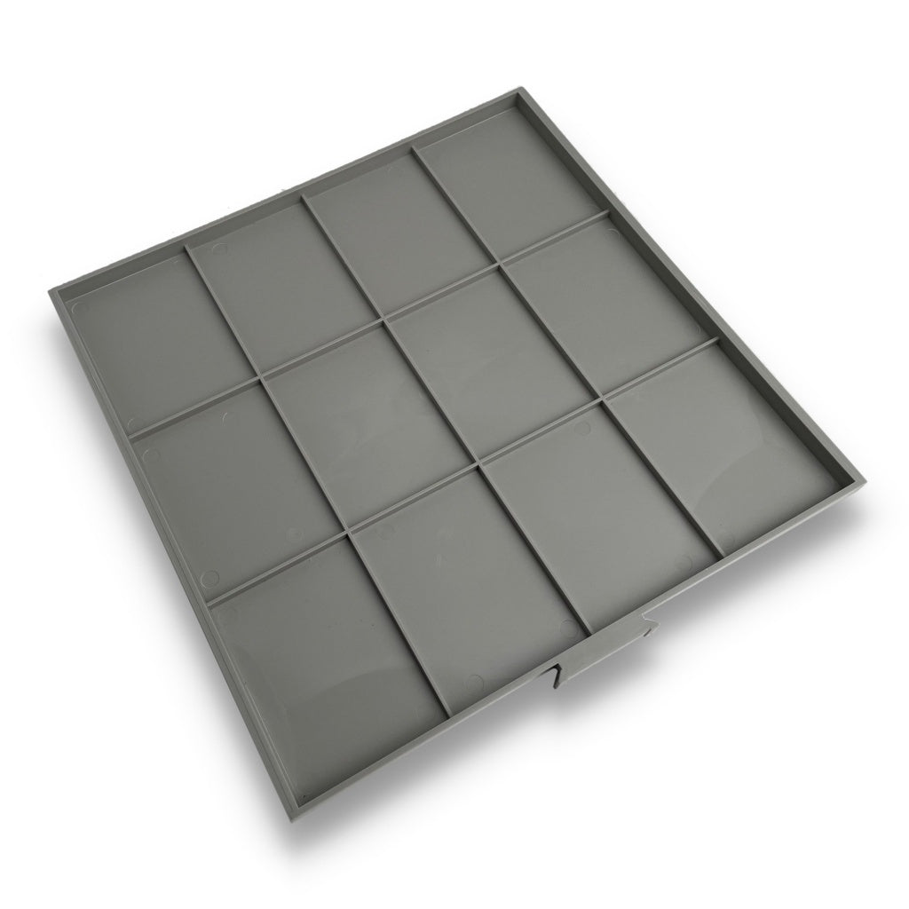 Gray grid coin tray drawer with empty compartments for a collection of graded coin slabs on a white background