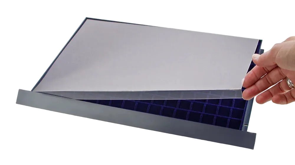 Hand lifting an acrylic protective cover of a drawer with a blue coin tray on a white background