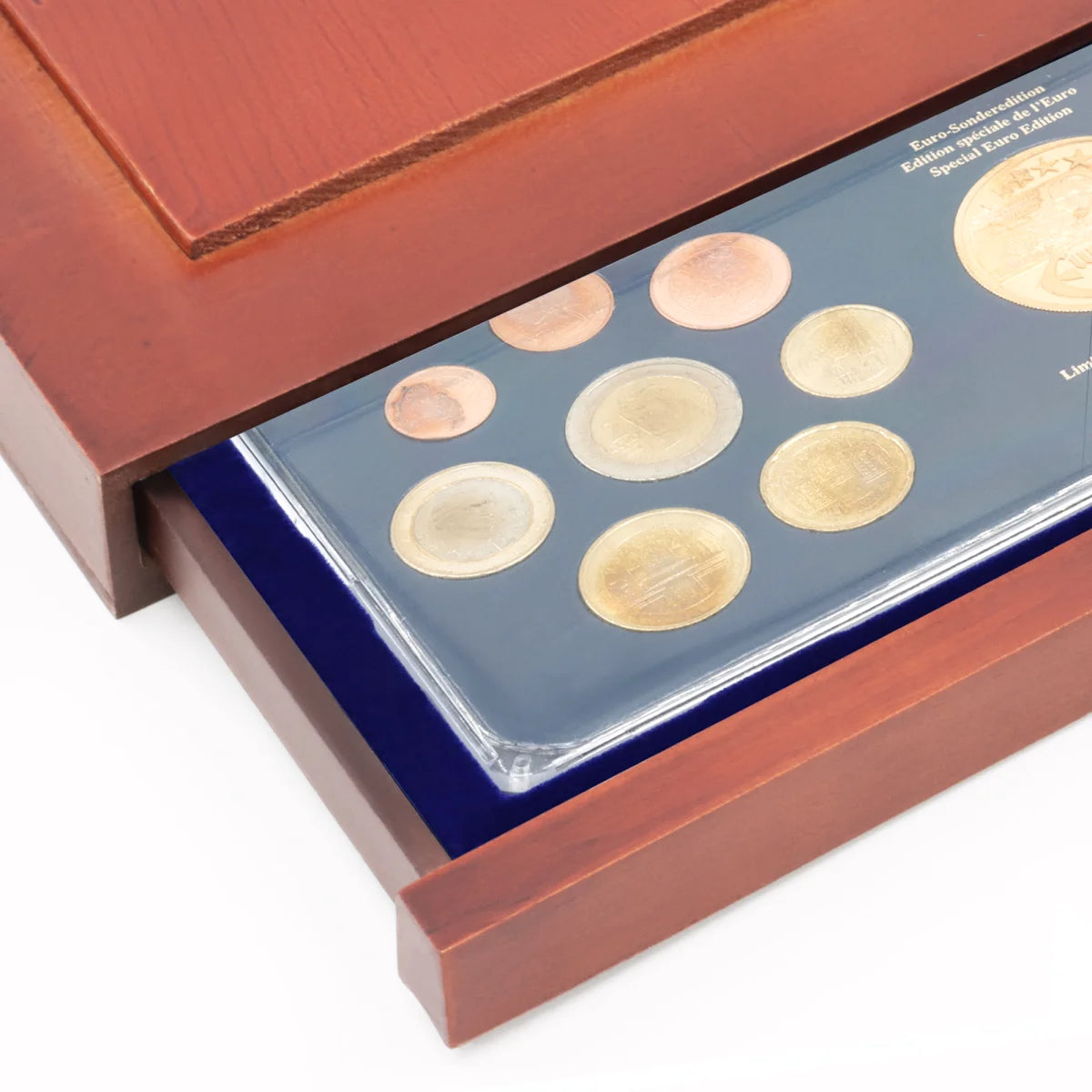 Detail shot of open wooden stackable drawer unit with a blue velvet tray for coin proof sets on a white background