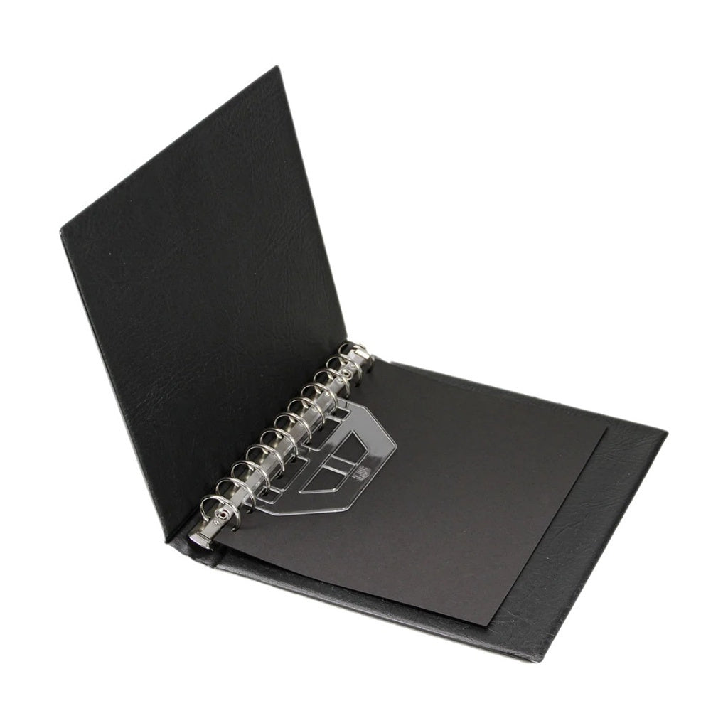Open black collector album showing an 11-ring mechanism on a white background