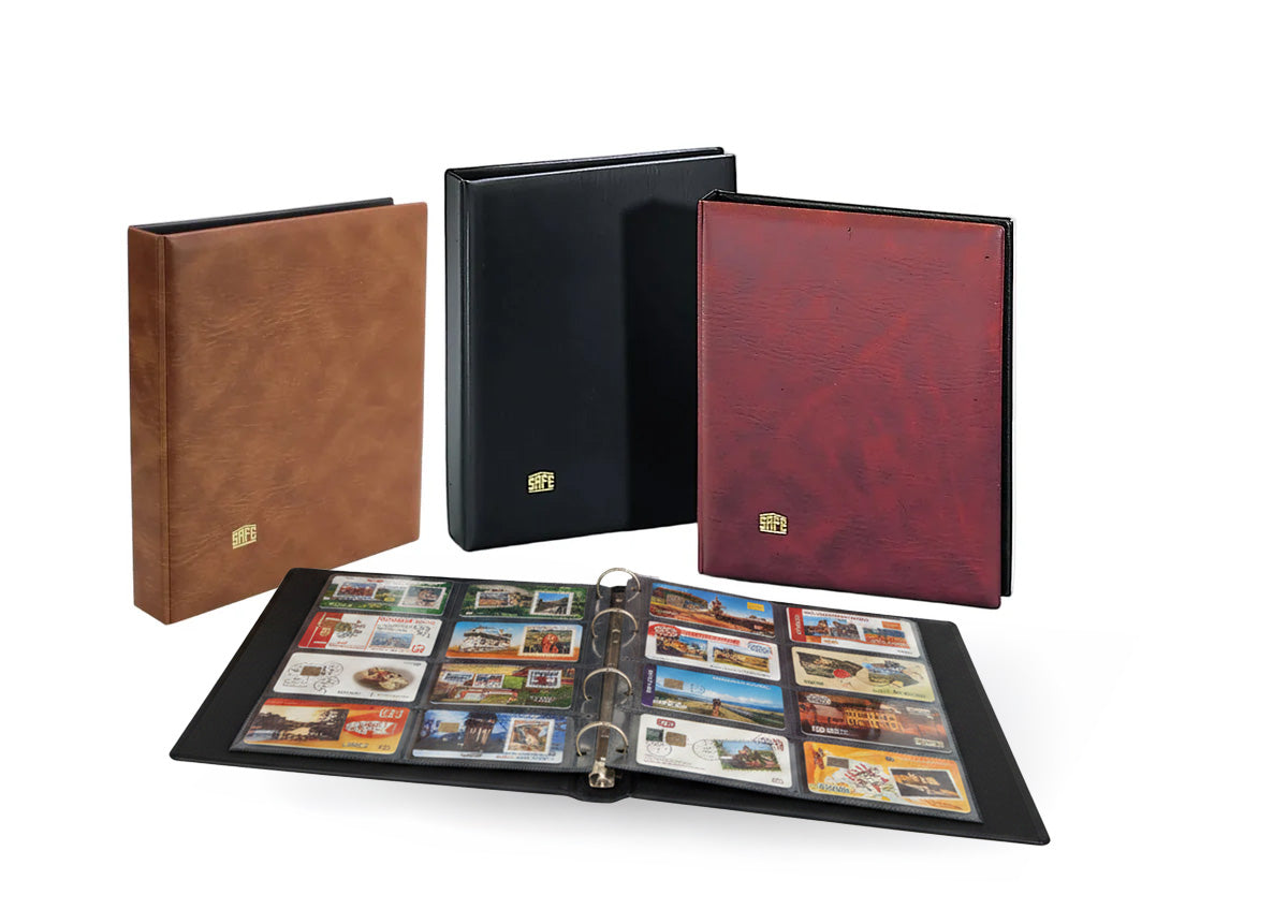 Collection of collectible telephone cards displayed in an open binder in front of a red album, brown album and black album on a white background.
