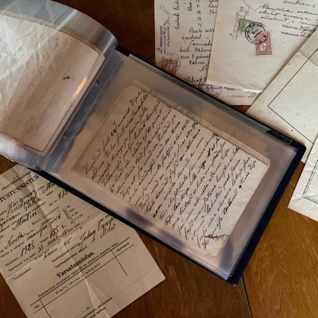 Collection of old letters, records/documents & ephemera in a binder on a wooden surface