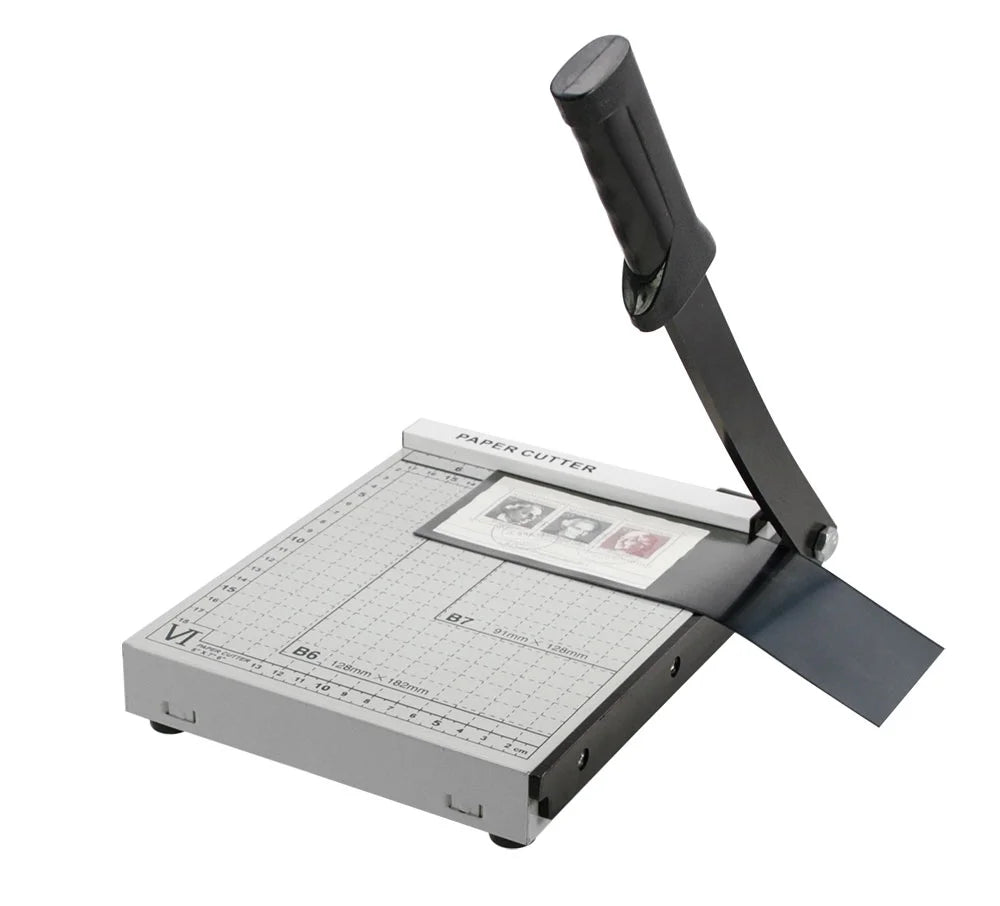 Grey measuring table and black handle paper cutter shown with a stamp mount on a white background