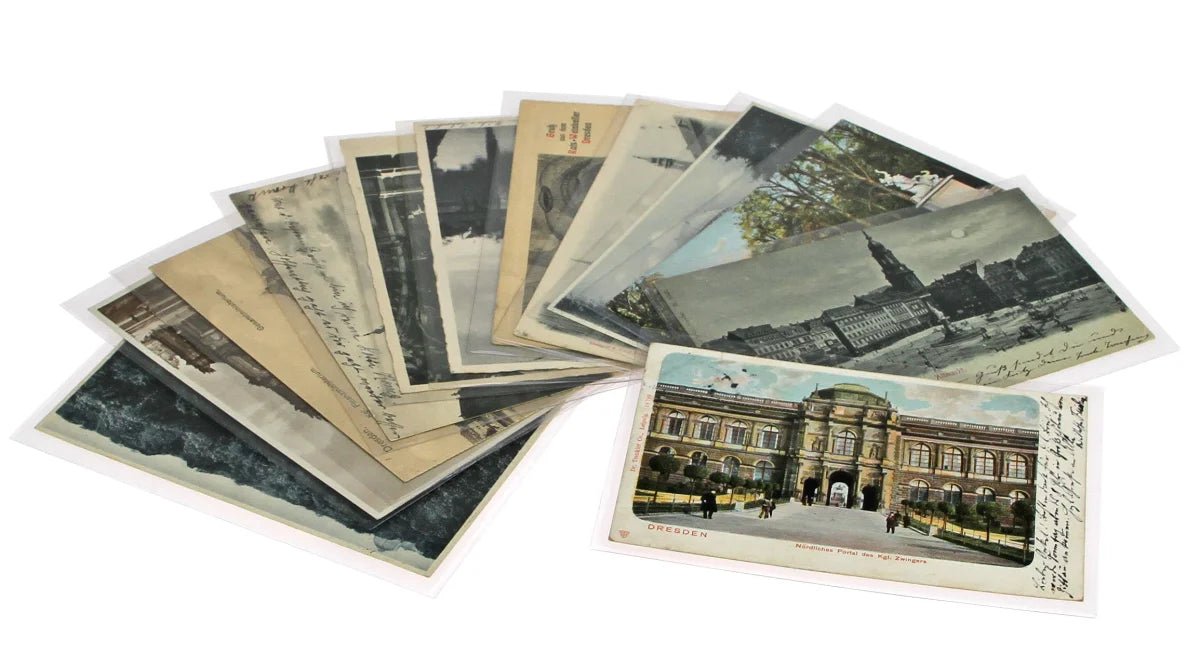 Collection of vintage postcards with architectural scenes inside protective sleeves on a white background