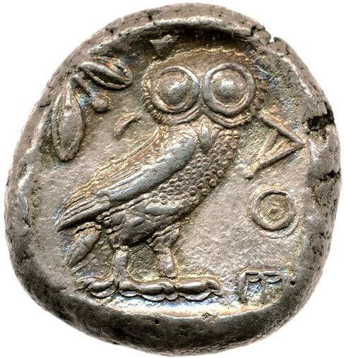 Ancient coin with an owl design on a white background