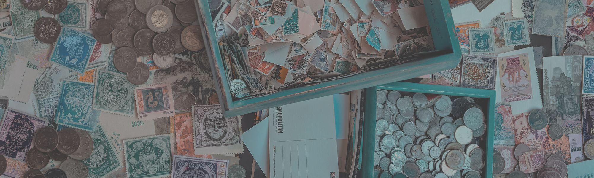 Collection of stamps, coins, postcards and more spread out, filling the entire image