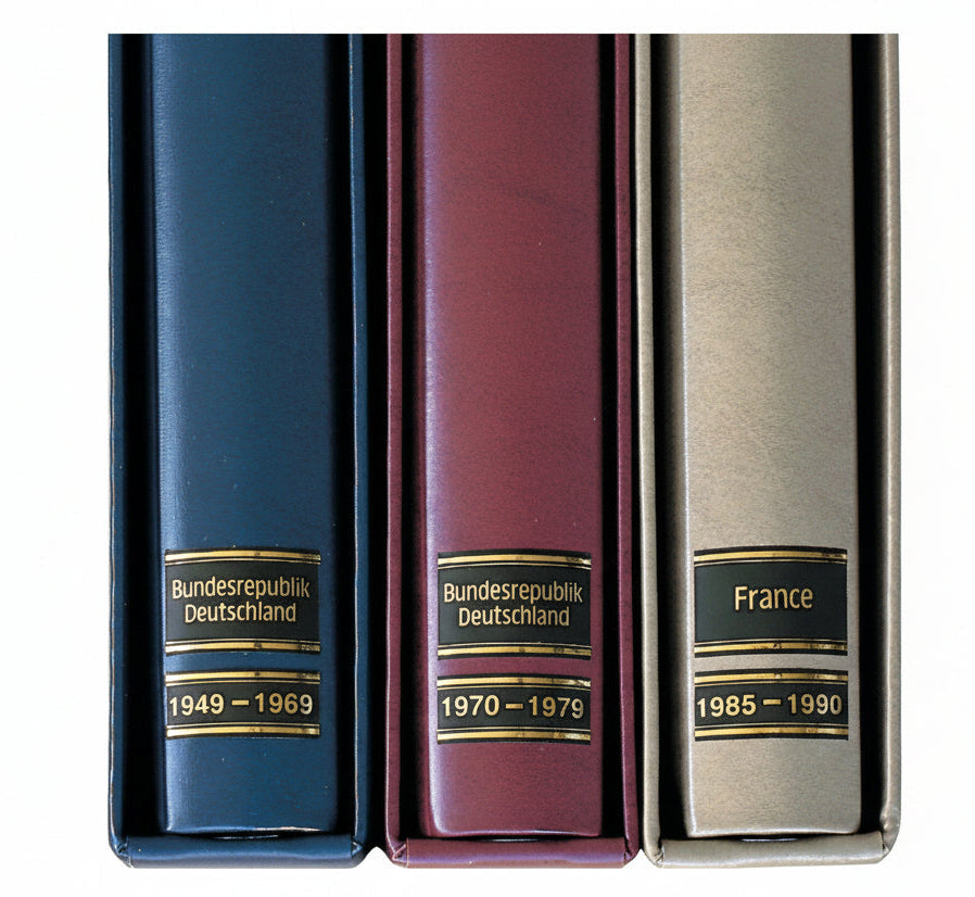 Three SAFE Albums with SAFE's black and gold embossed country and year labels for album spine labeling/organizing on a white background