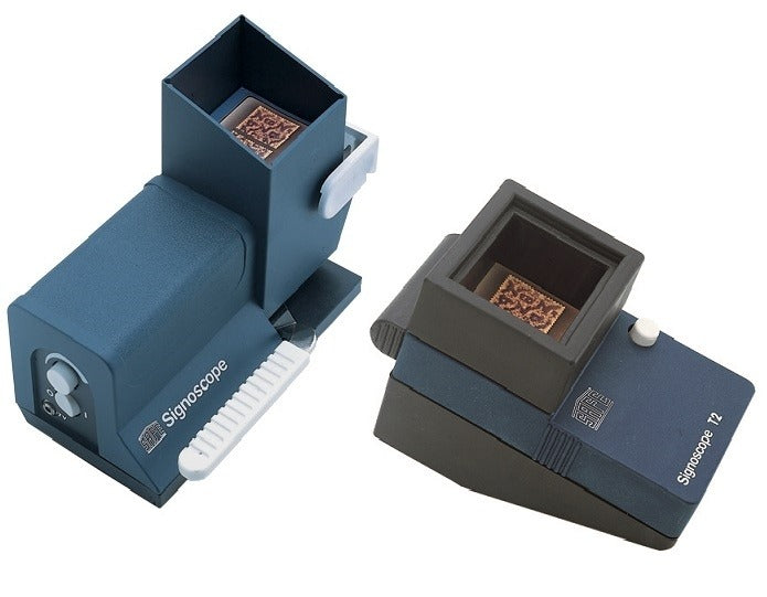Two SAFE Signoscopes (stamp watermark detectors) on a white background