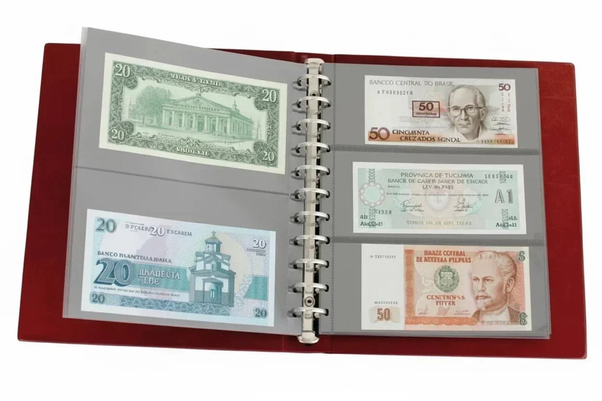 Collection of banknotes inside transparent pages displayed in an open red currency album on a white background
