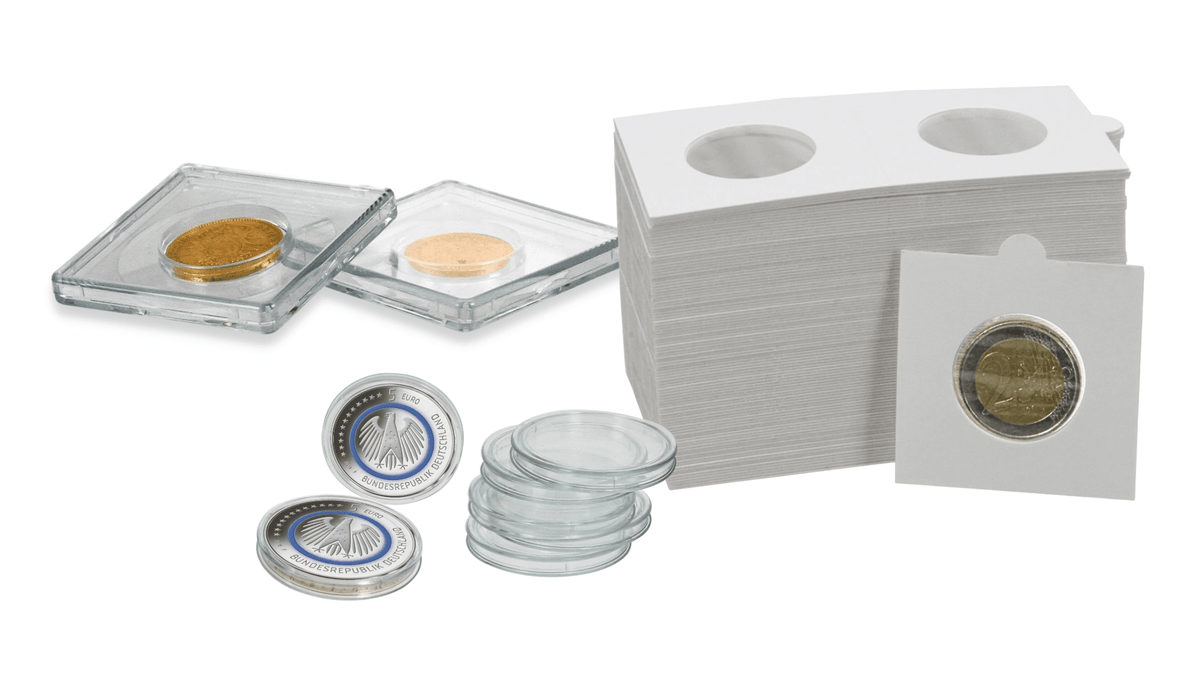 Clear acrylic coin holders, a stack of white card sleeves with circular cutouts, several clear round coin protectors, and a few sample coins inside holders.