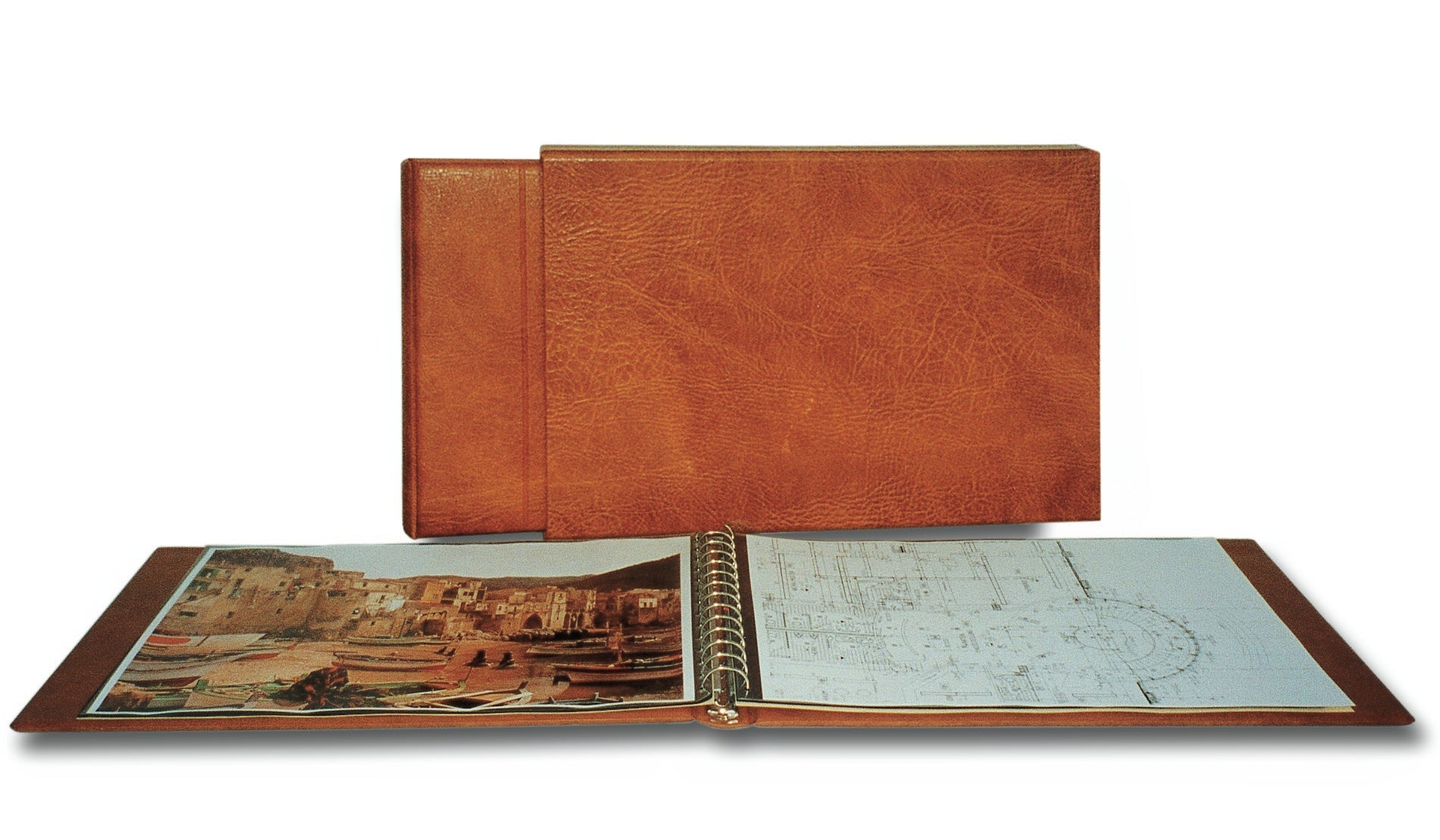 Tan album with an open album in front displaying art and blueprints on a white background