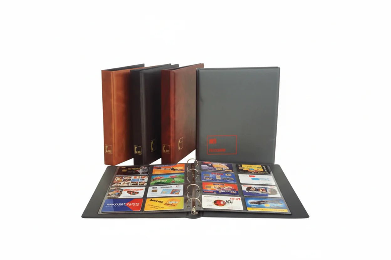 Collection of collectible telephone cards displayed in an open binder in front of a red album, brown album and black album on a white background.