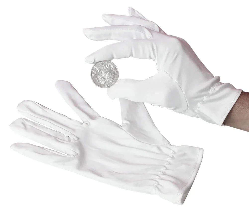A hand wearing a white cotton coin glove holding a silver coin on a white background