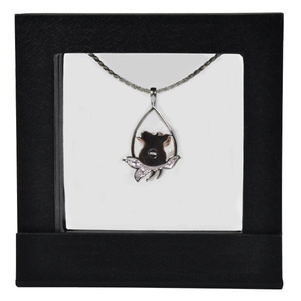 Black square frame/shadowbox with transparent window made of film that is molded to a necklace pendant on a white background