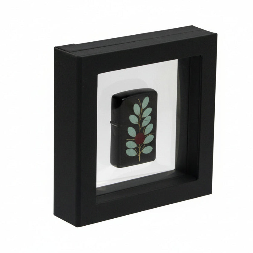 Black square frame/shadowbox with transparent window made of film that is molded to a Zippo lighter on a white background