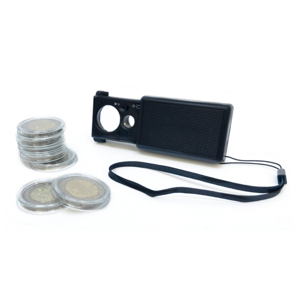 Black slide out magnifier with two lenses and a light on a white background shown next to a stack of Euros in coin capsules