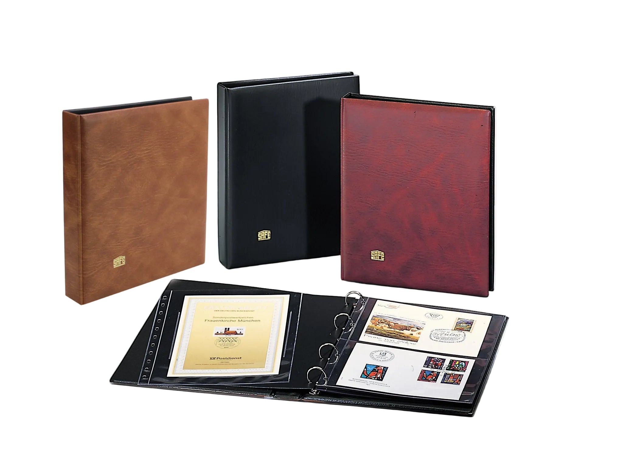 Three albums in red, black and brown, with an open album displaying FDC's on a white background