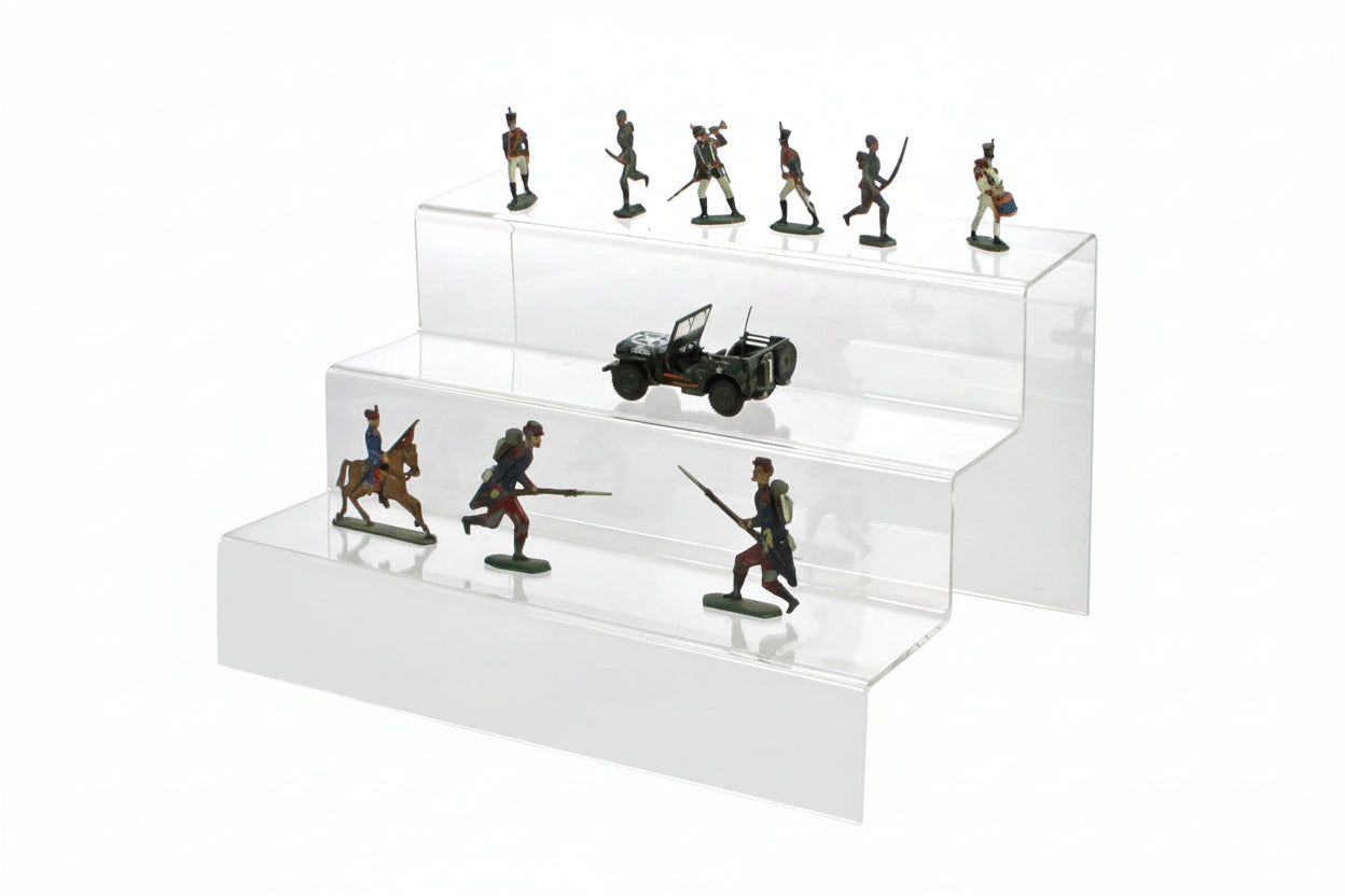 Collection of toy soldiers and a jeep on a clear acrylic display steps against a white background