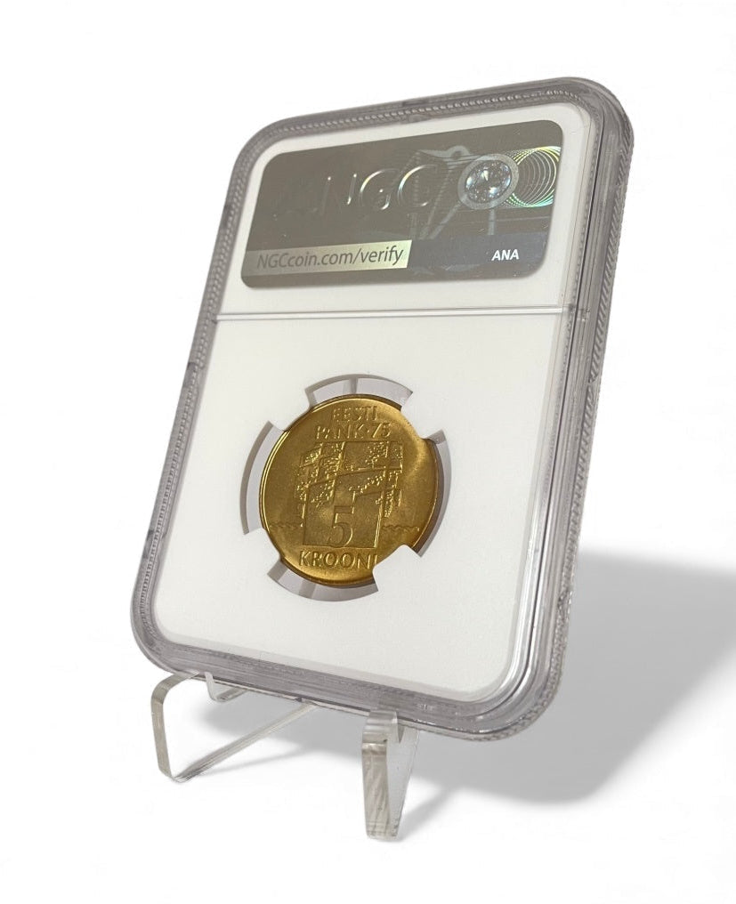 Gold coin in a protective holder with NGC (Numismatic Guaranty Corporation) branding, placed on a triangular acrylic display easel, on a white background