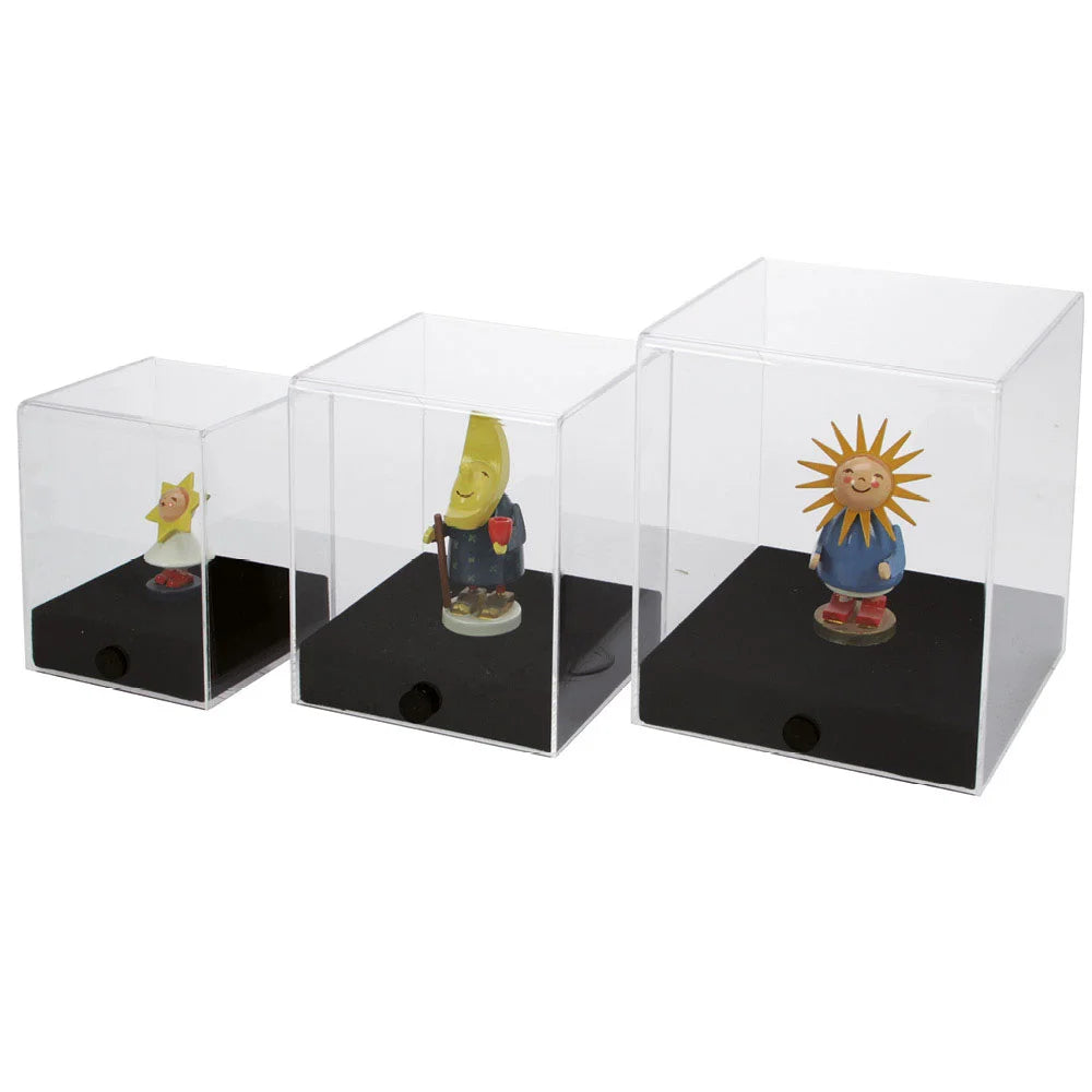 Three figurines in acrylic display cube cases with black bases on a white background