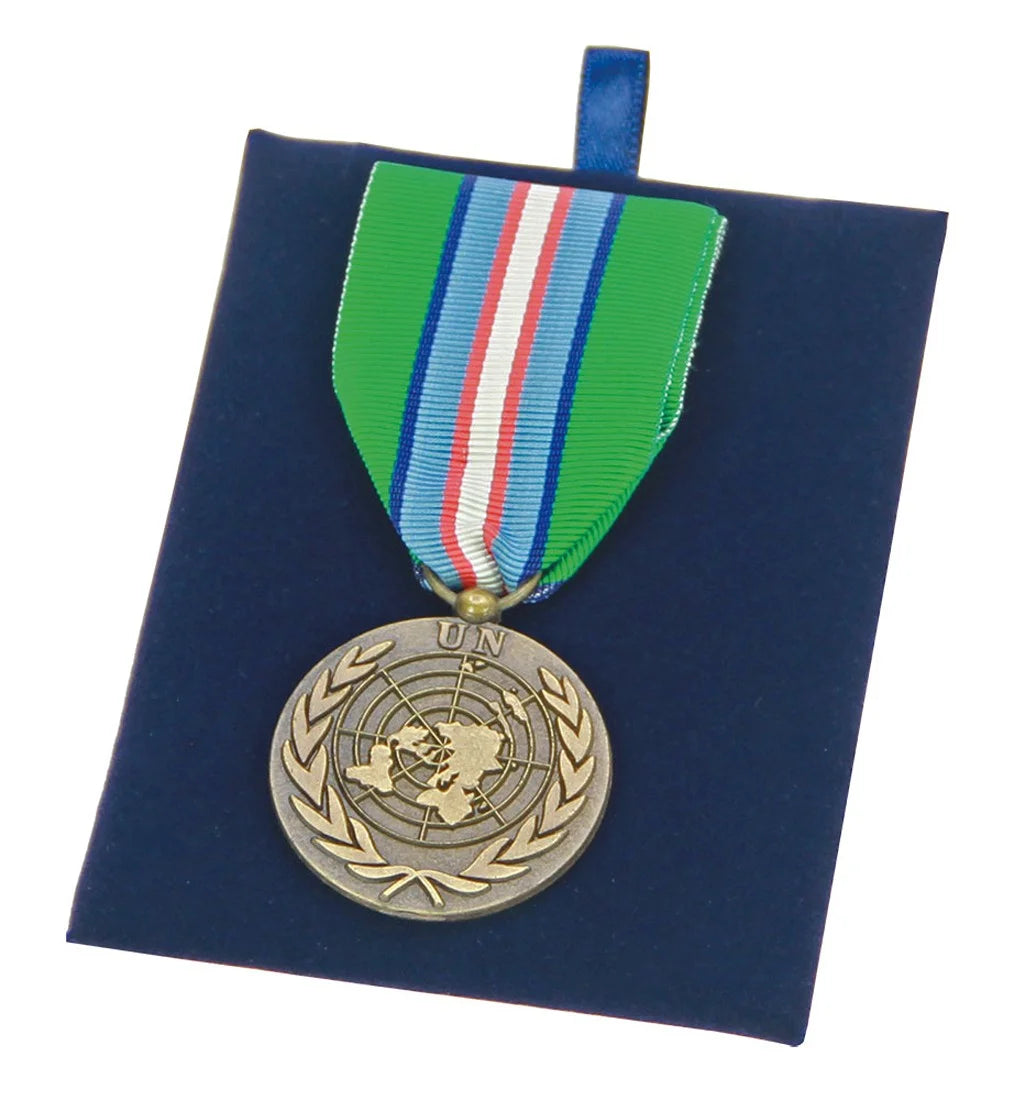 Medal with UN emblem on a blue velvet removable cushion on a white background