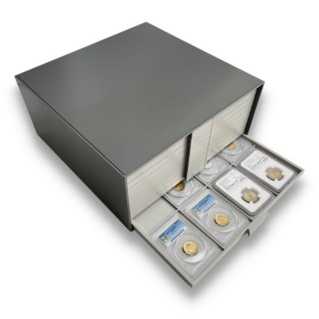 Overhead image of gray coin drawer unit with an open drawer showing a collection of graded coin slabs on a white background