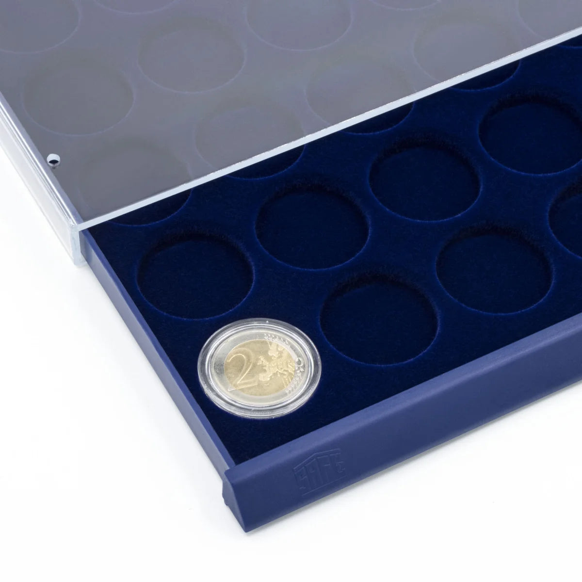 Detail shot of open acrylic stackable drawer unit with a blue velvet tray and circular compartments for coins on a white background
