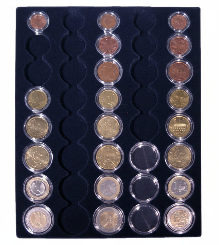 Overhead shot of a blue velvet tray and circular compartments holding euro coin sets in capsules on a white background